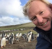 Kevin Millington with penguins in Eastern Caribbean