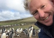 Kevin Millington with penguins in Eastern Caribbean